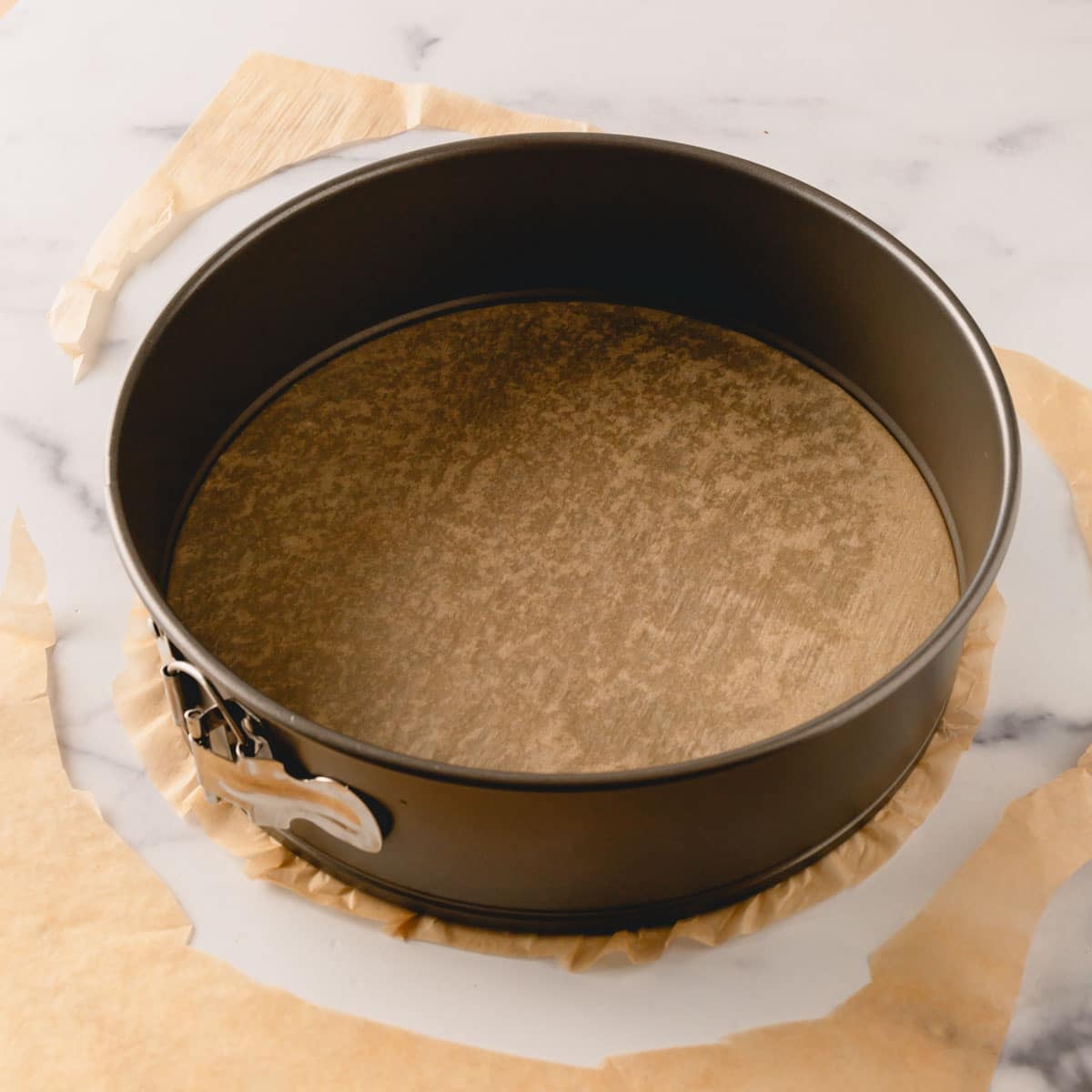 A springform pan on top of parchment paper.