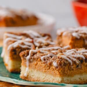 Pumpkin streusel bars topped with icing on a plate.