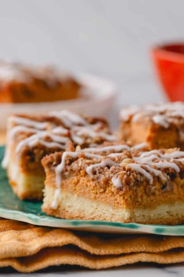 Pumpkin streusel bars topped with icing on a plate.