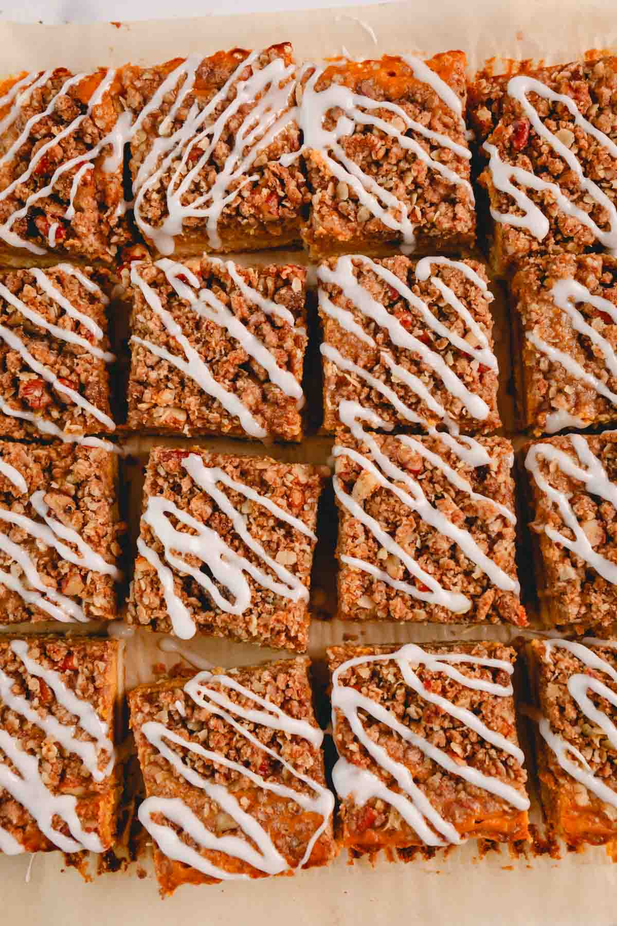 Pumpkin streusel bars topped with icing cut into squares.