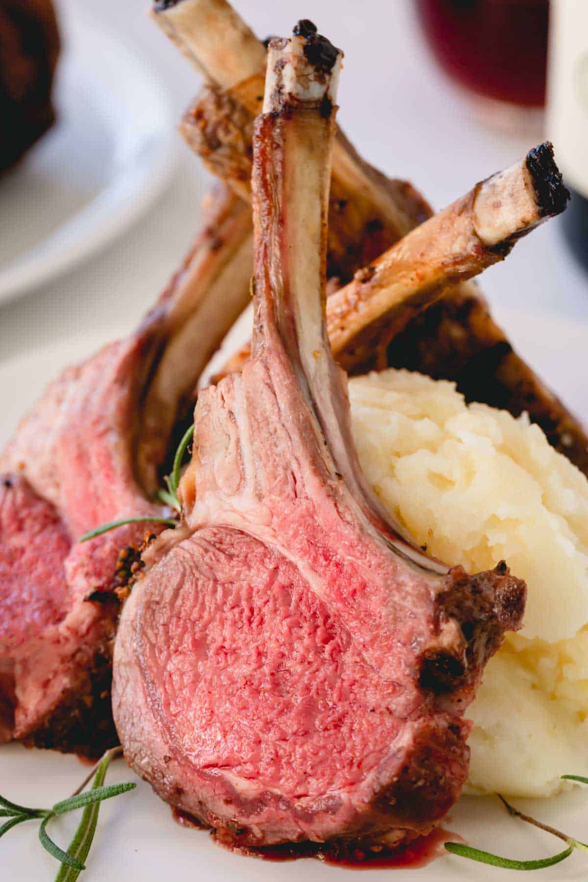 Sliced roasted rack of lamb with mashed potatoes.