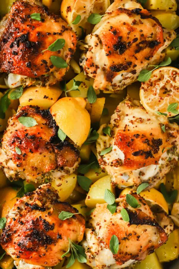Greek lemon chicken and potatoes topped with fresh herbs.