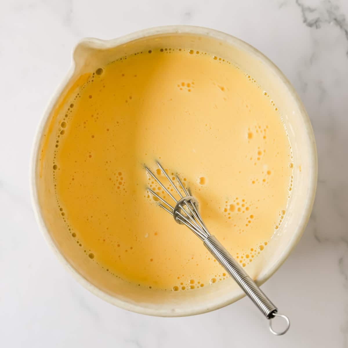 The custard filling for a ham and cheese quiche.
