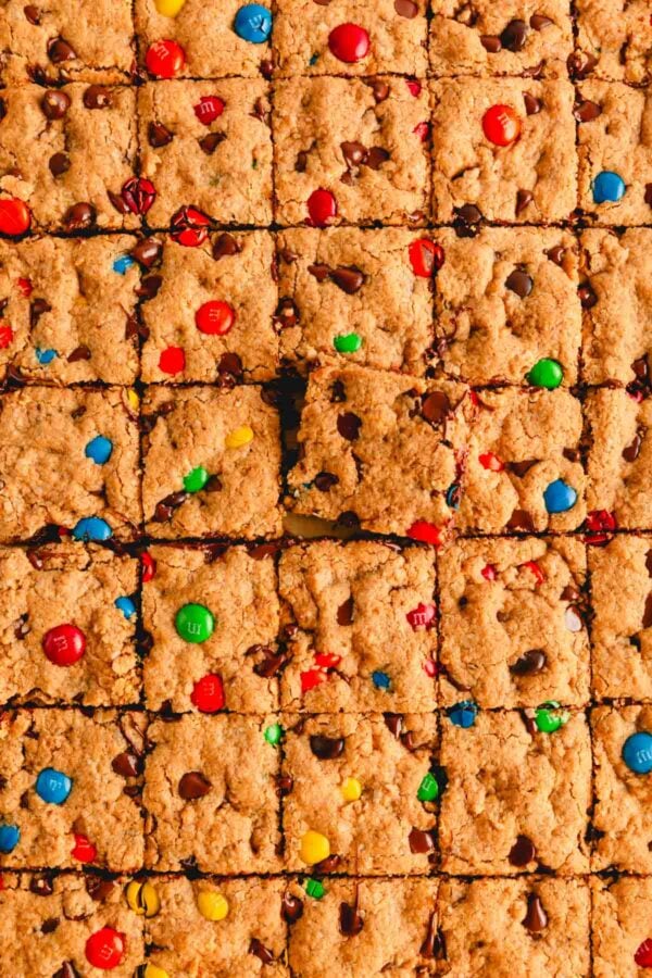 Sliced monster cookie bars with one square sticking up.