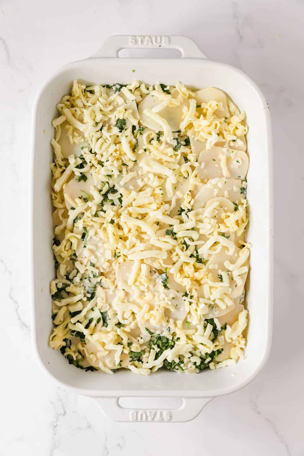 Cream mixture poured over the potato slices and sprinkled with cheese.