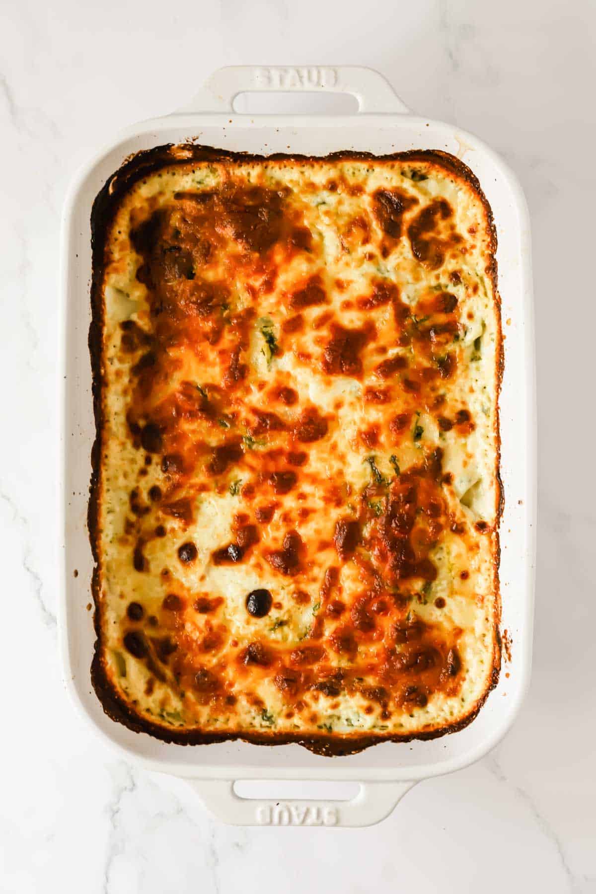 Baked scalloped potatoes in a baking dish with browned top.