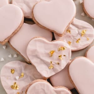 Raspberry sugar cookies decorated with pink icing and gold leaf.