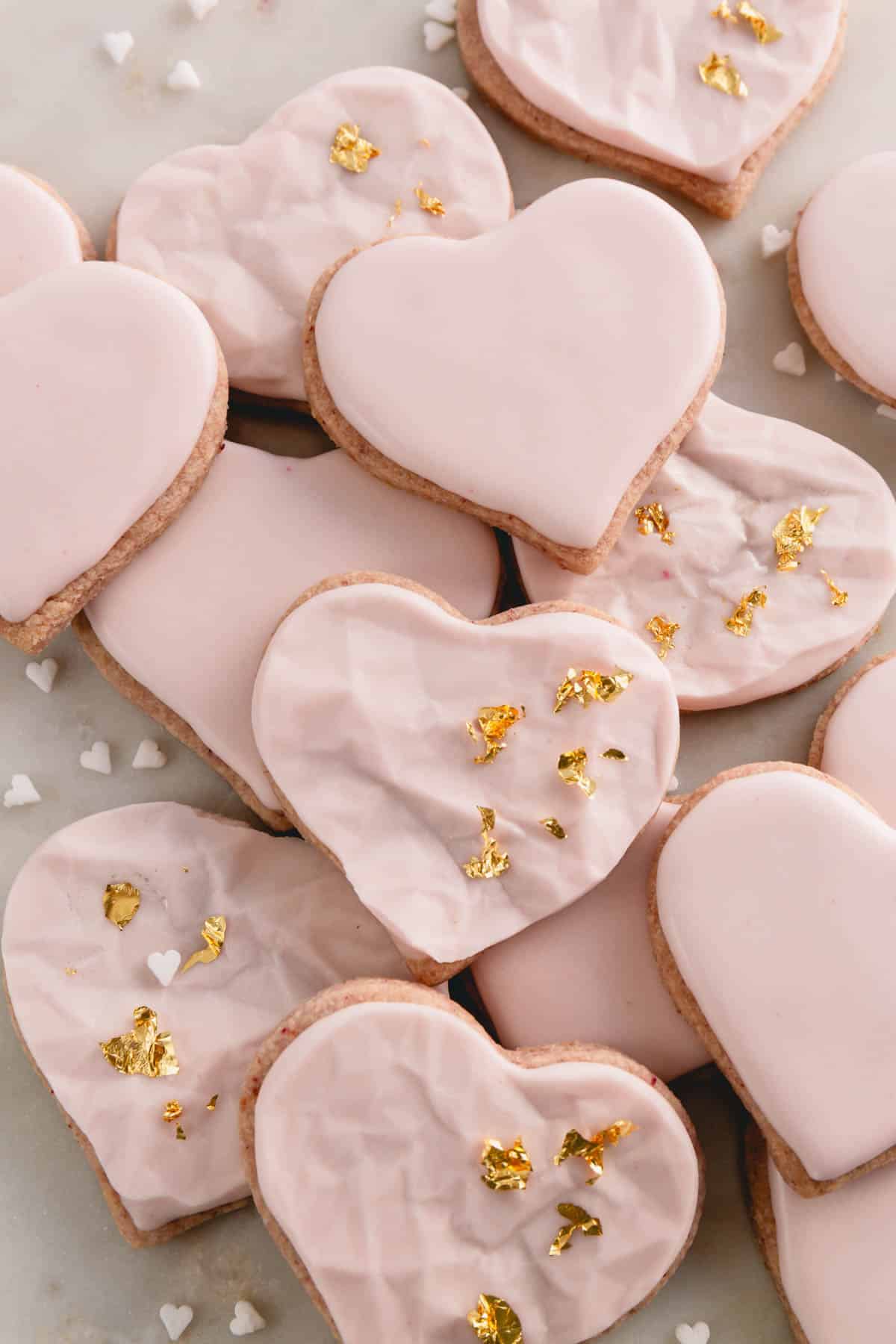 Raspberry sugar cookies decorated with pink icing and gold leaf.