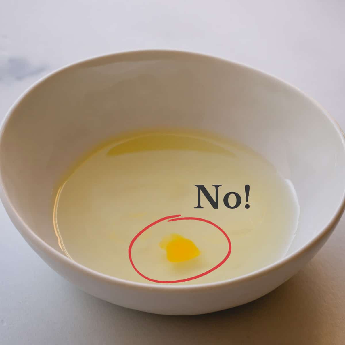 A bowl of egg whites with a small drop of egg yolk and a text says "NO!"