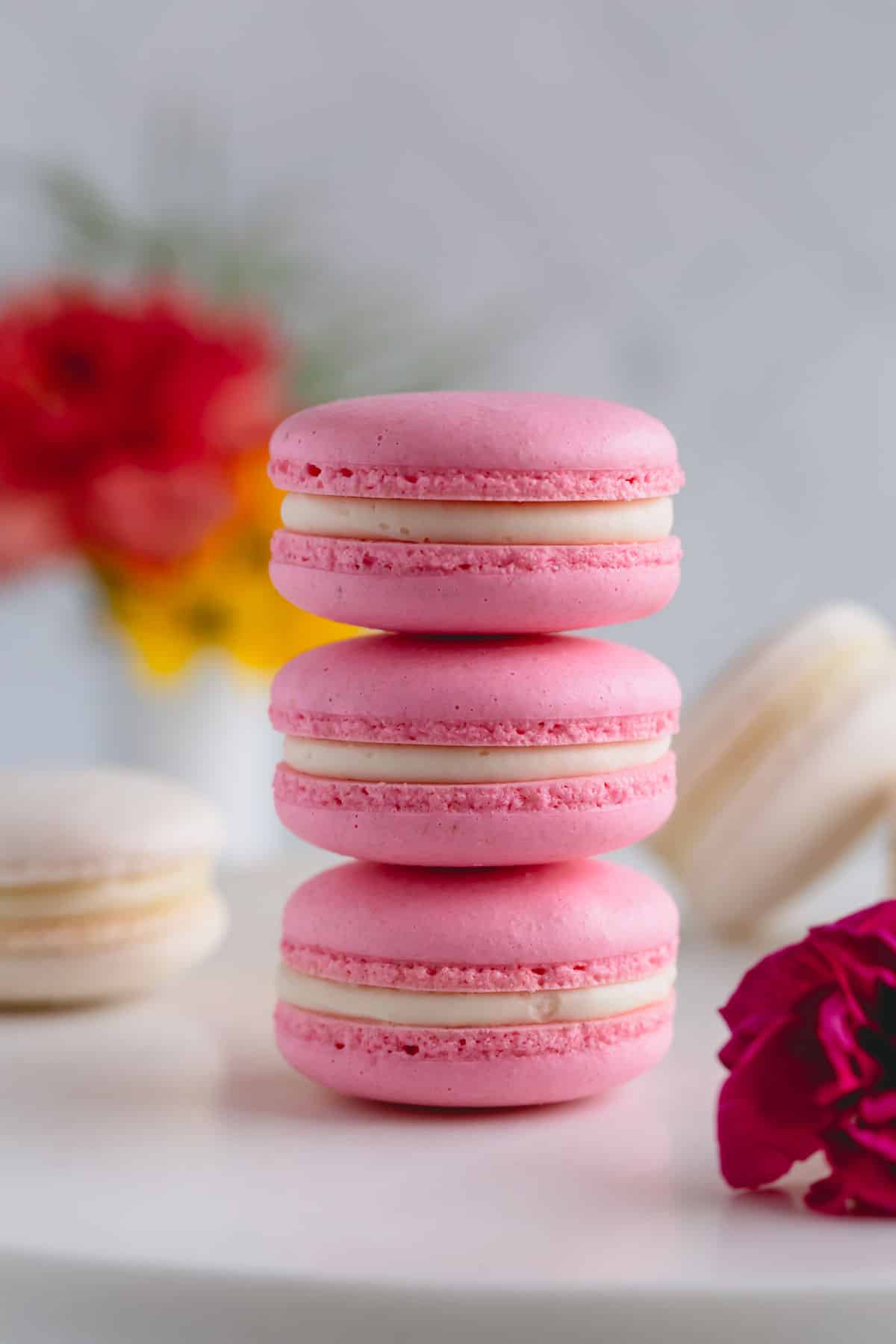 3 pink macarons stacked on top of each other.