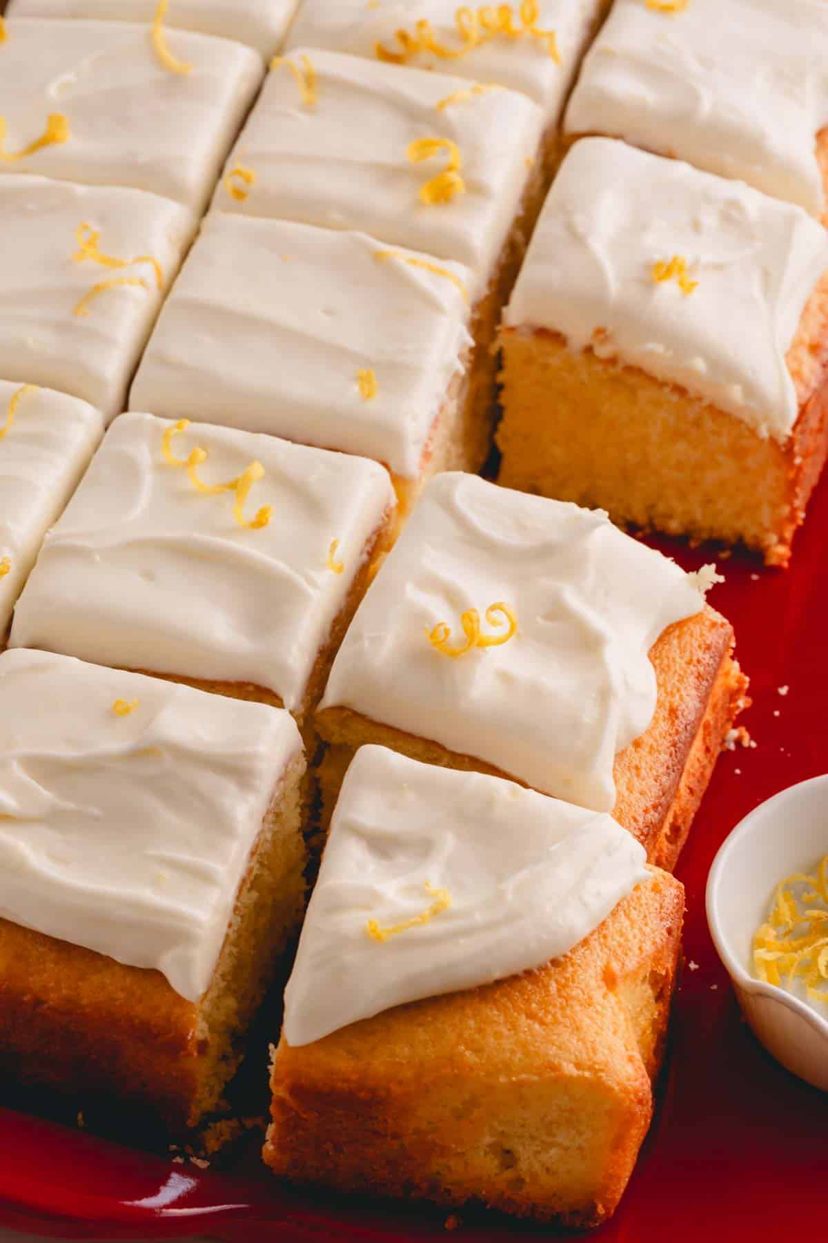 Squares of yellow cake topped with lemon cream cheese frosting.