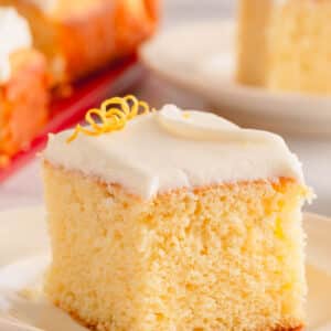 A slice of lemon sheet cake topped with lemon cream cheese icing.