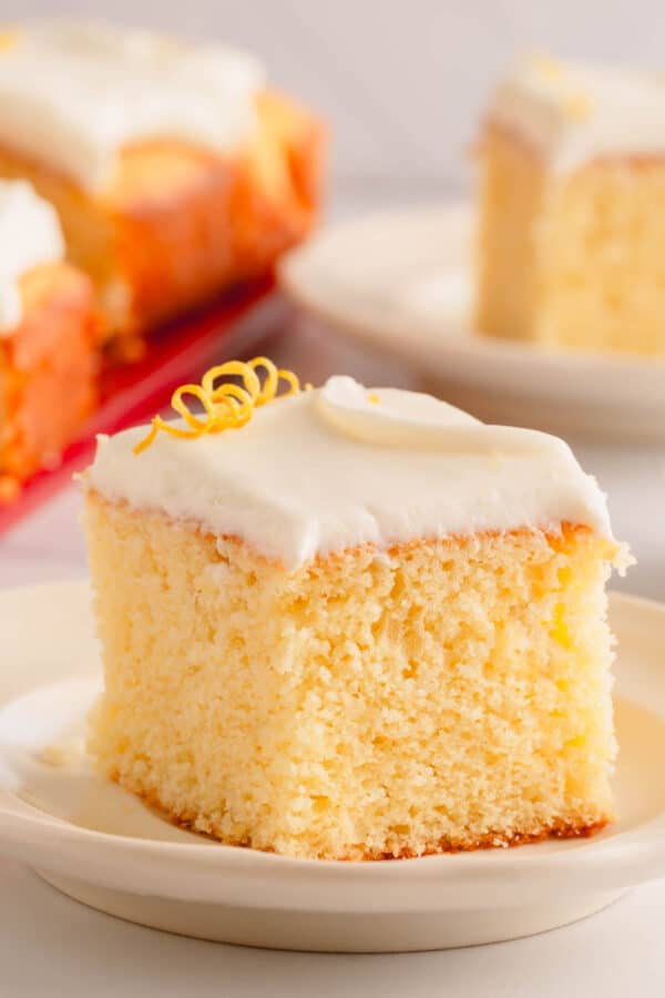 A slice of lemon sheet cake topped with lemon cream cheese icing.
