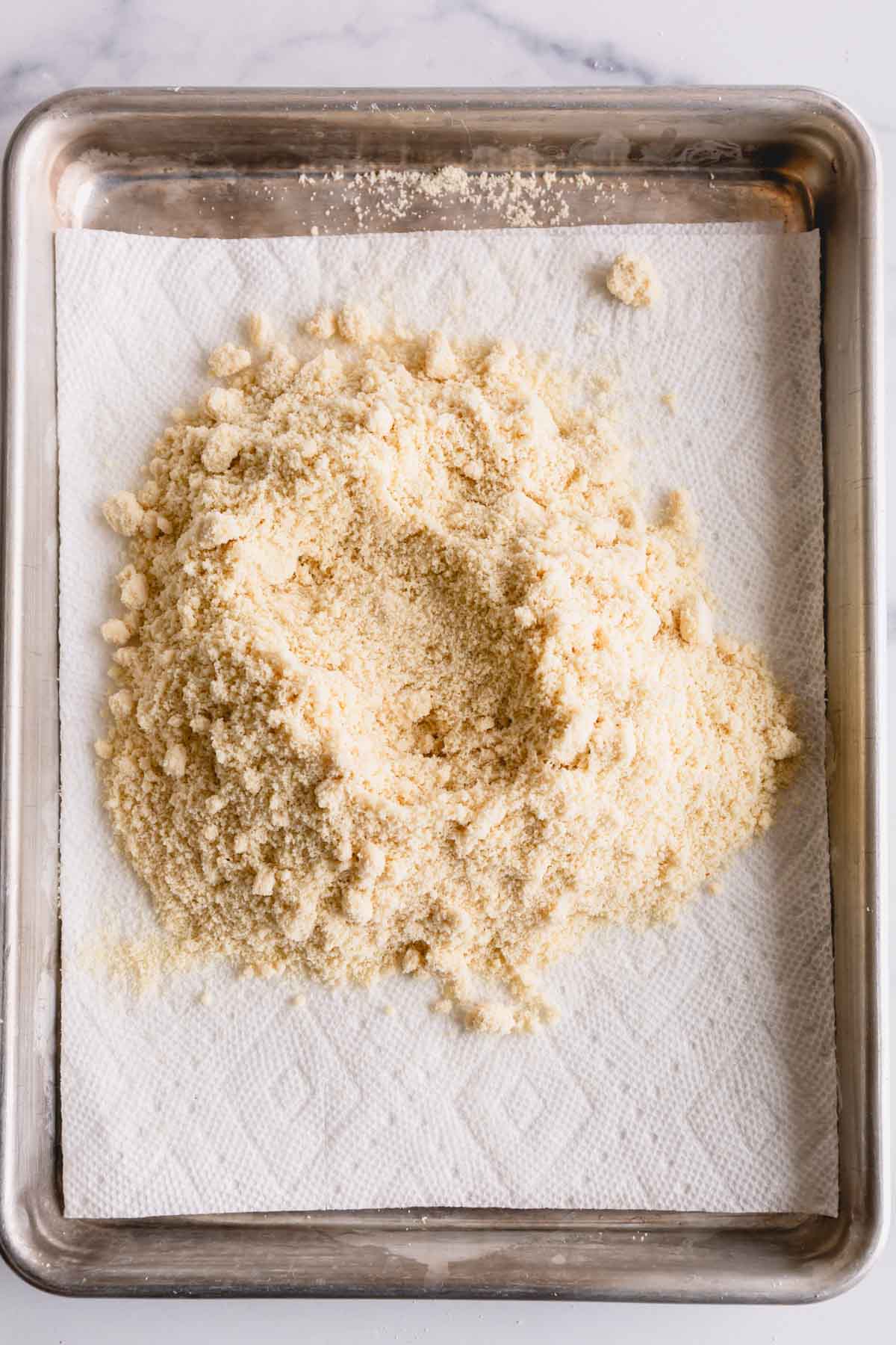 Almond flour on a baking sheet lined with paper towel.