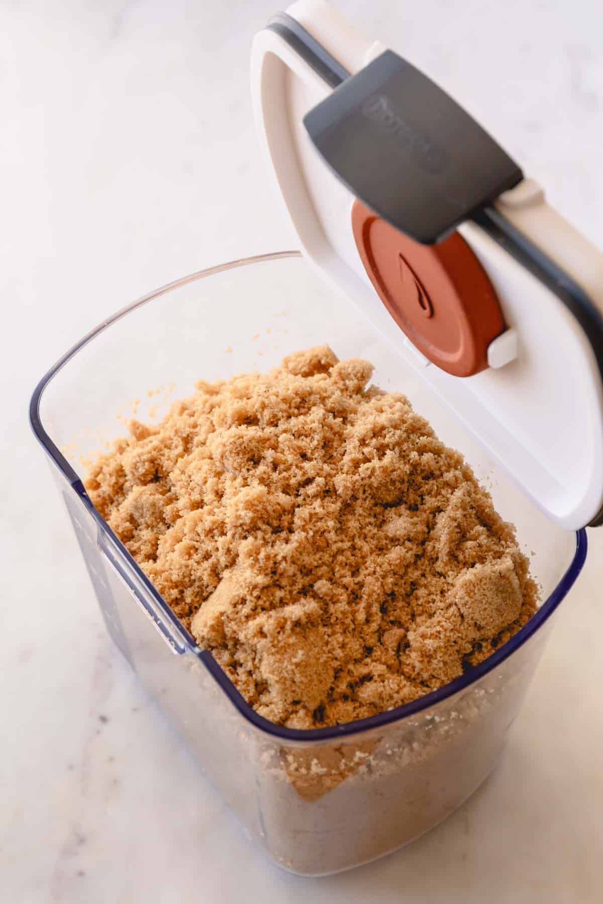 Soft brown sugar in a brown sugar container with a terra cota disk attached to the lid.