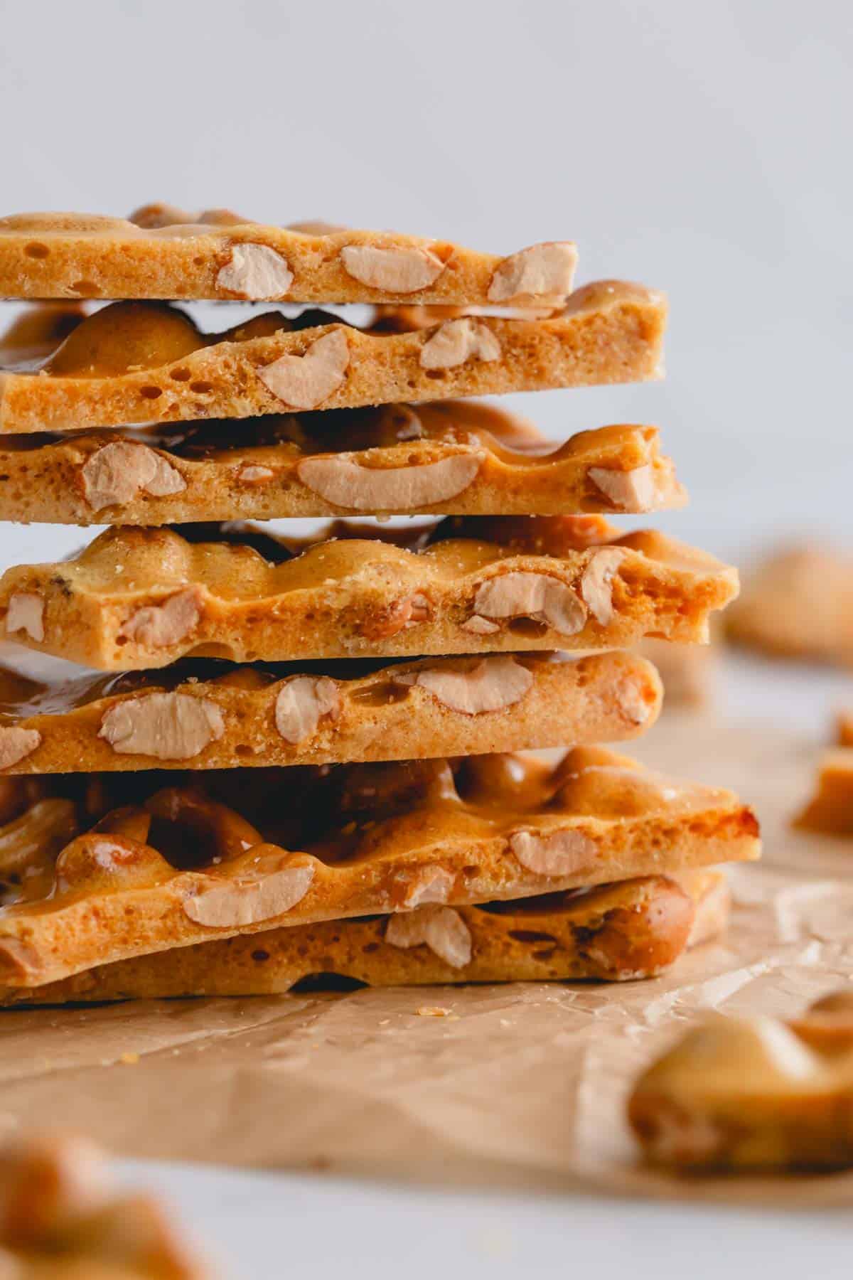 A stack of homemade peanut brittle pieces on top of each other.
