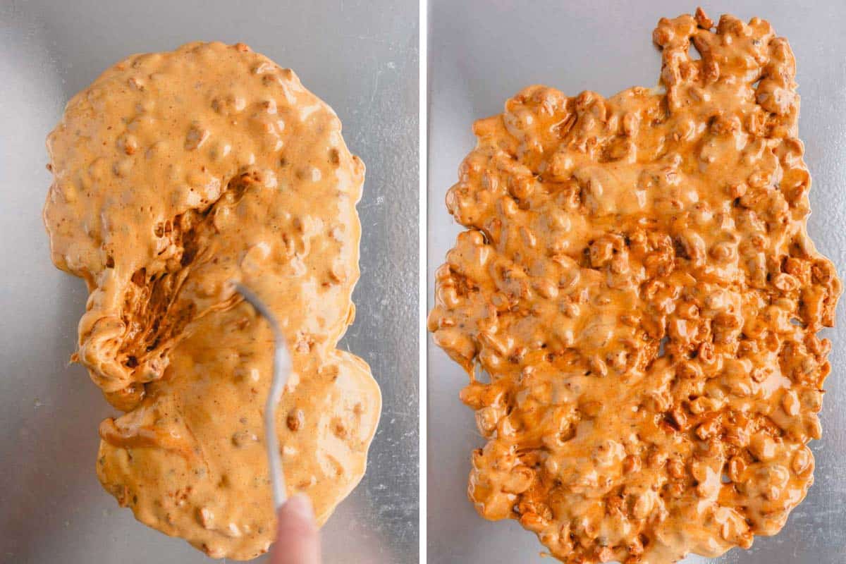 A peanut brittle mixture being spread evenly over a baking sheet.