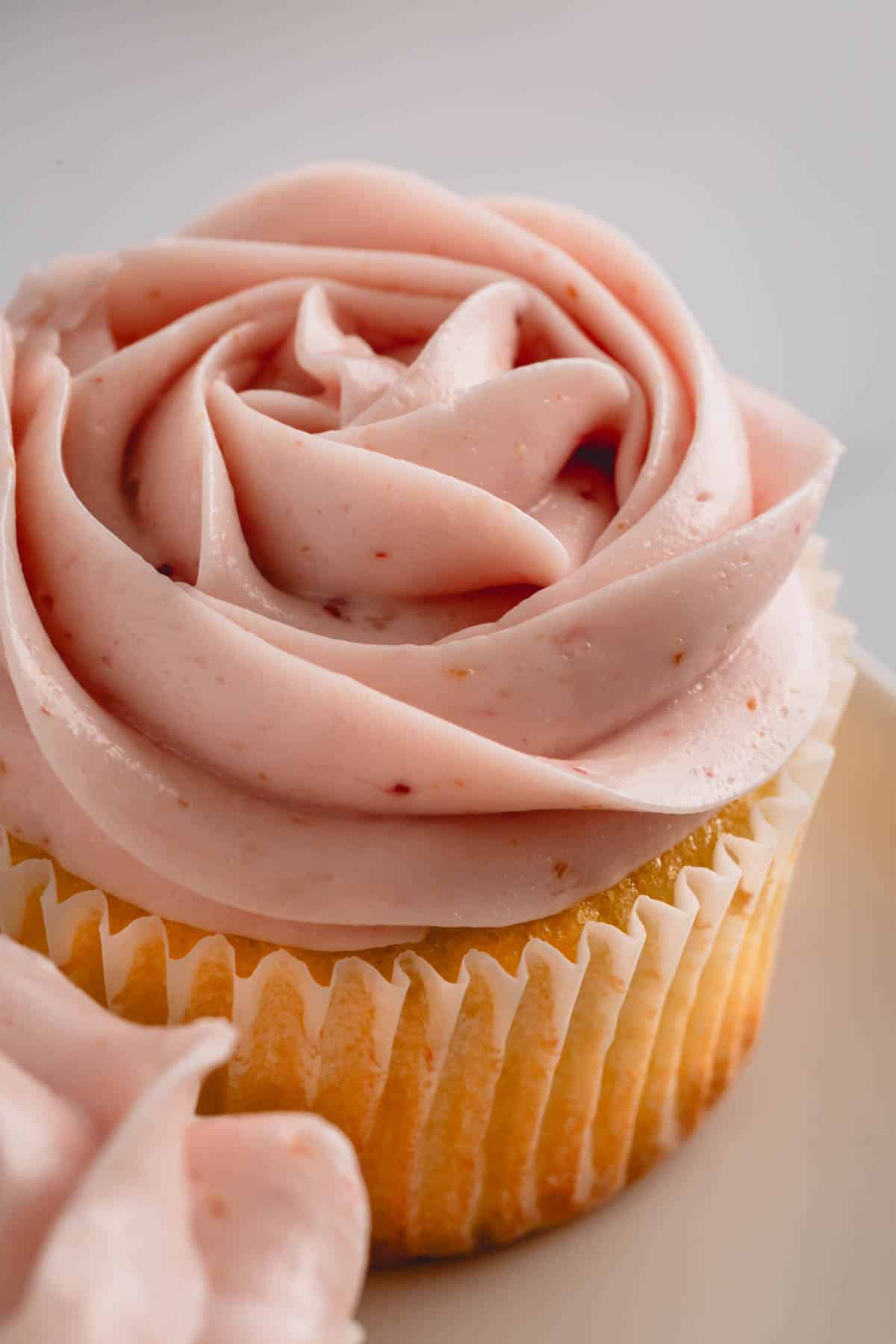A vanilla cupcake topped with raspberry buttercream.
