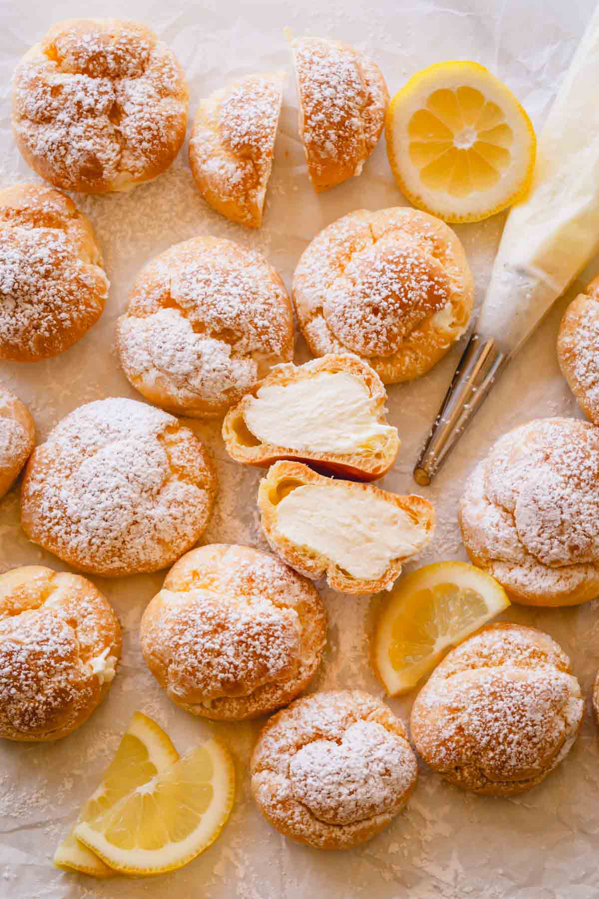 Lemon creme puffs with one split in half exposing the filling.