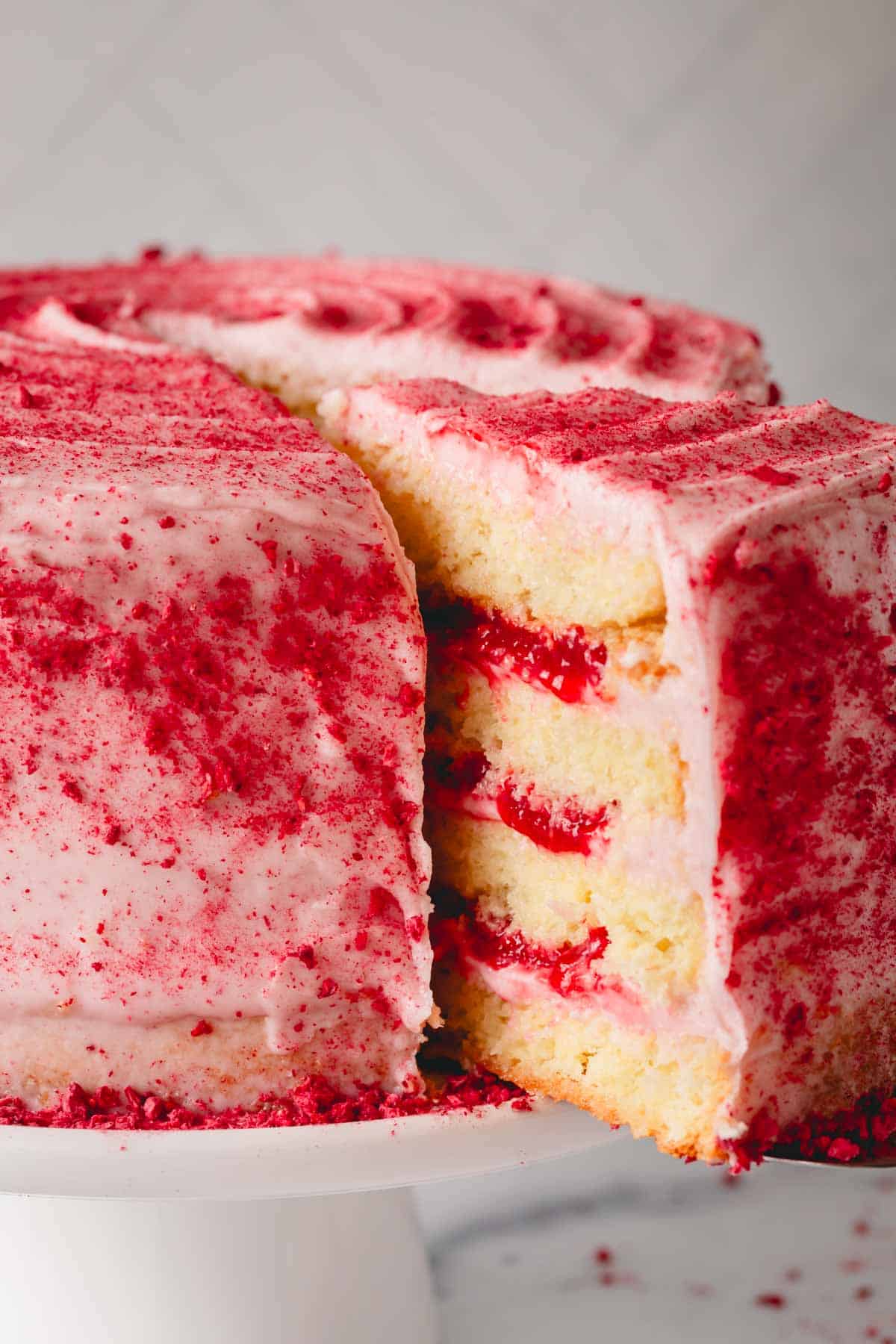 A raspberry layered sponge cake with raspberry frosting.