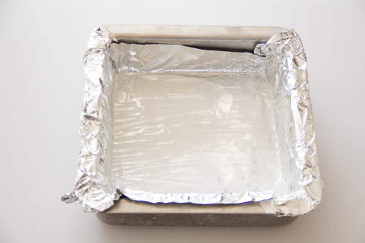 A square baking dish lined with aluminum foil.