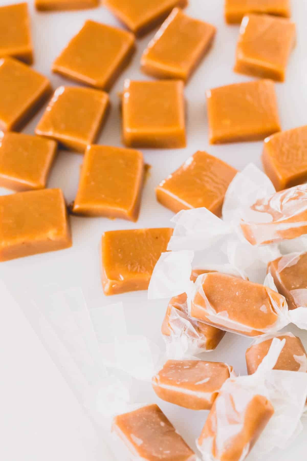 Cardamom caramel candies, some wrapped with parchment paper.