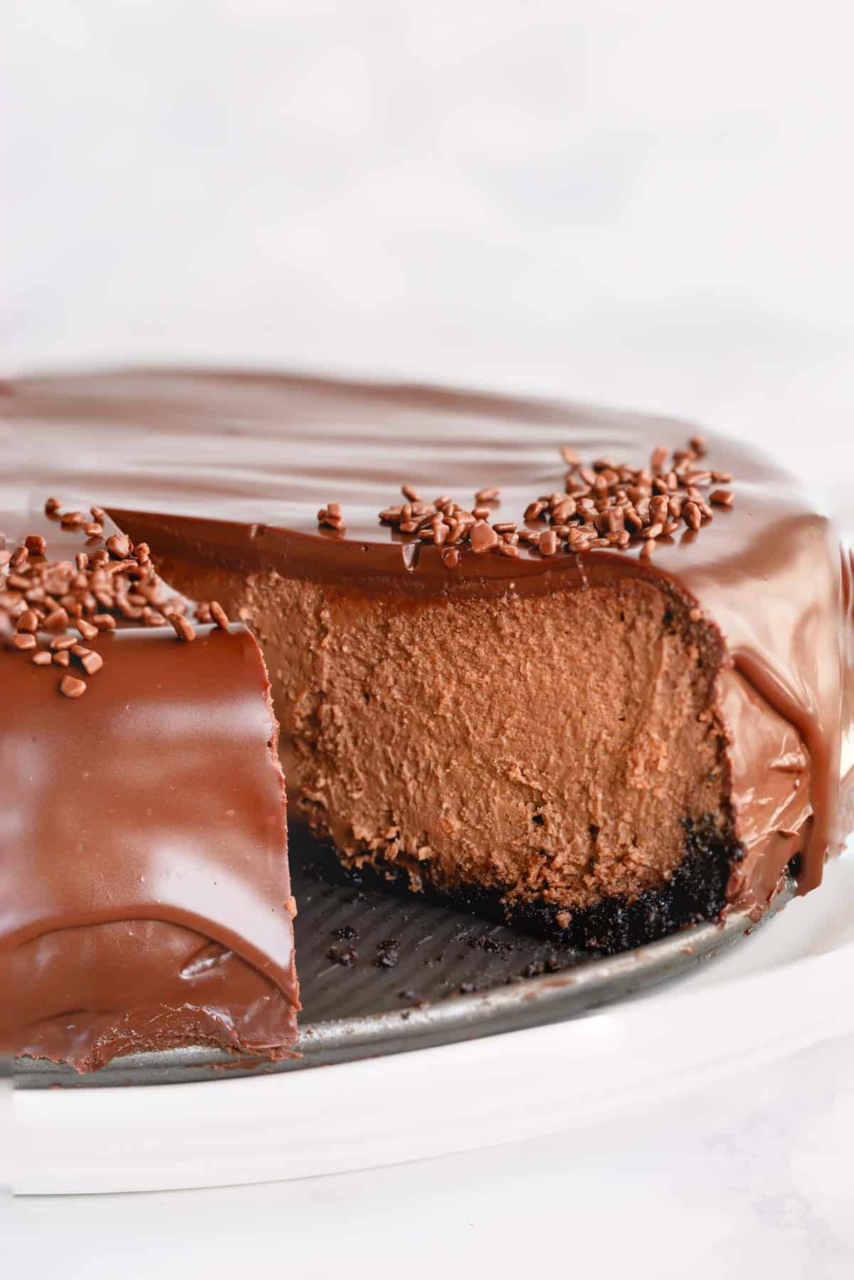 Supreme chocolate cheesecake with a slice missing. 