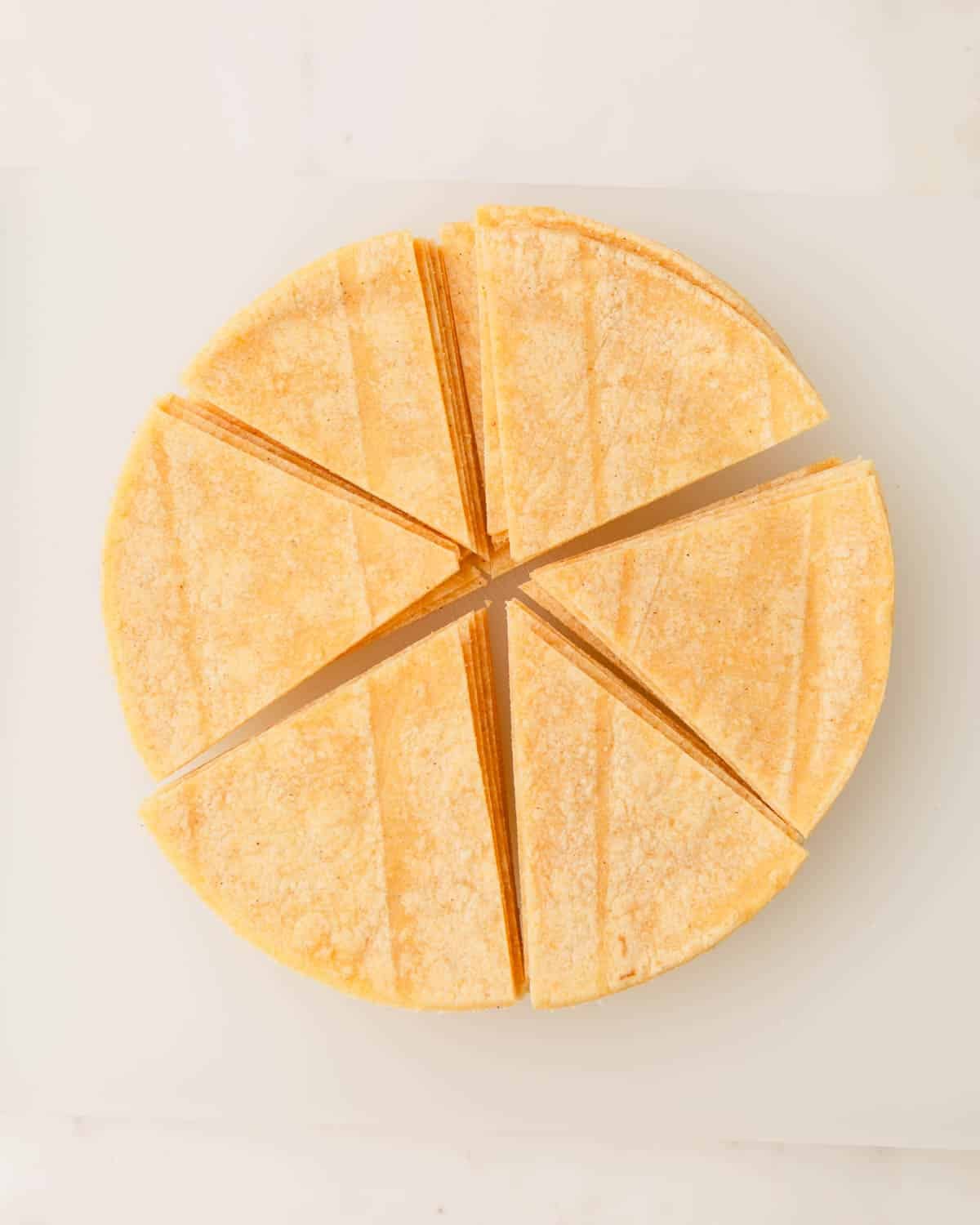 A stack of corn tortillas cut into six pieces.