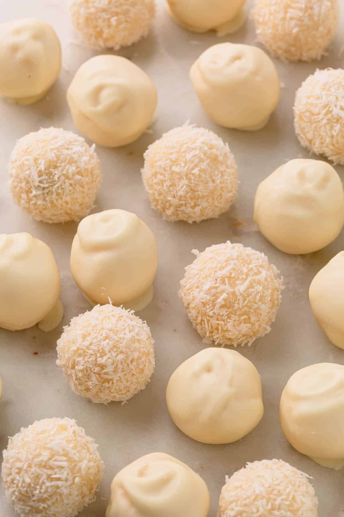 Coconut balls coated with white chocolate and others covered with desiccated coconut.