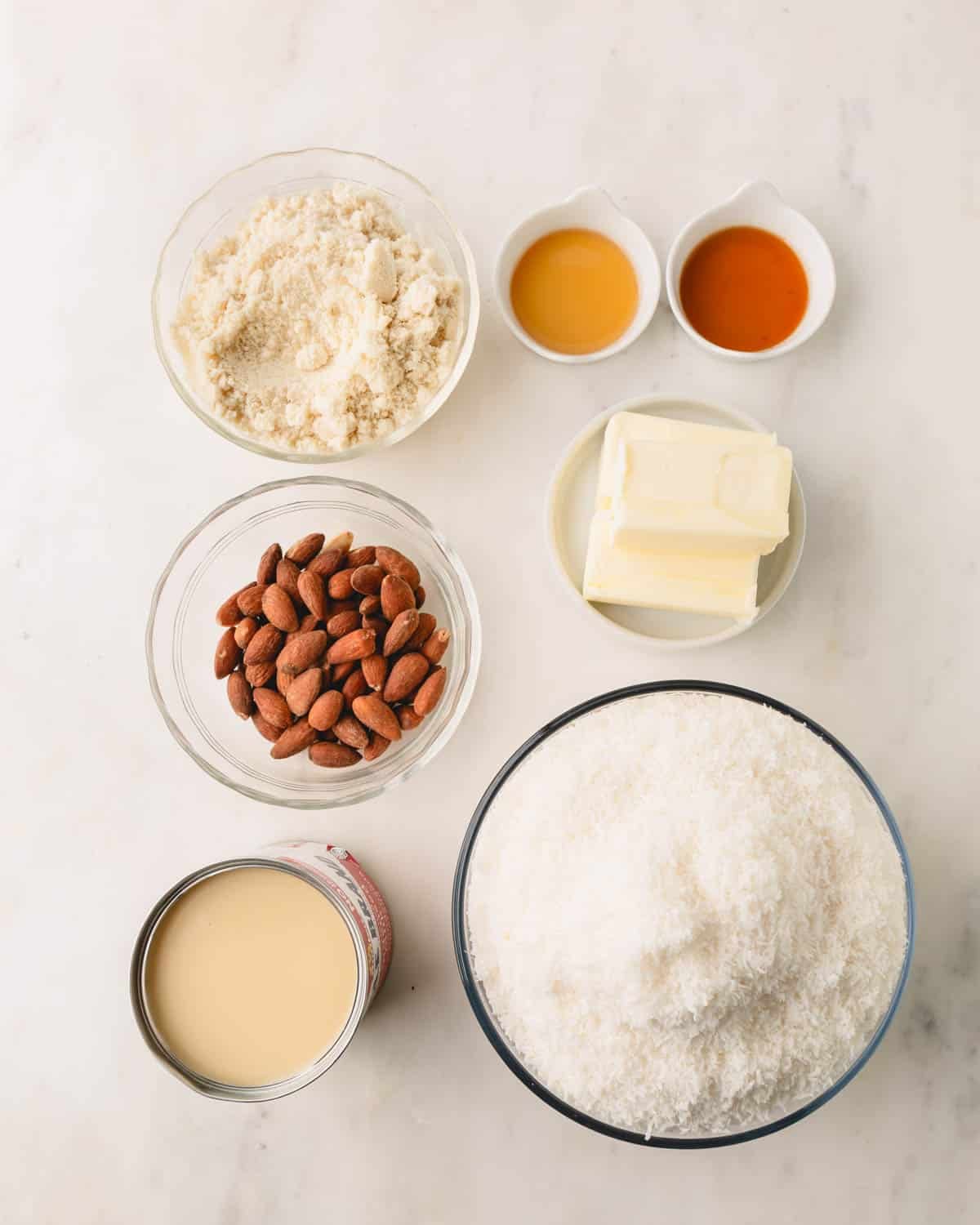 Almond flour, whole pecans, condensed milk, desiccated coconut, butter, vanilla extract, and maple syrup.