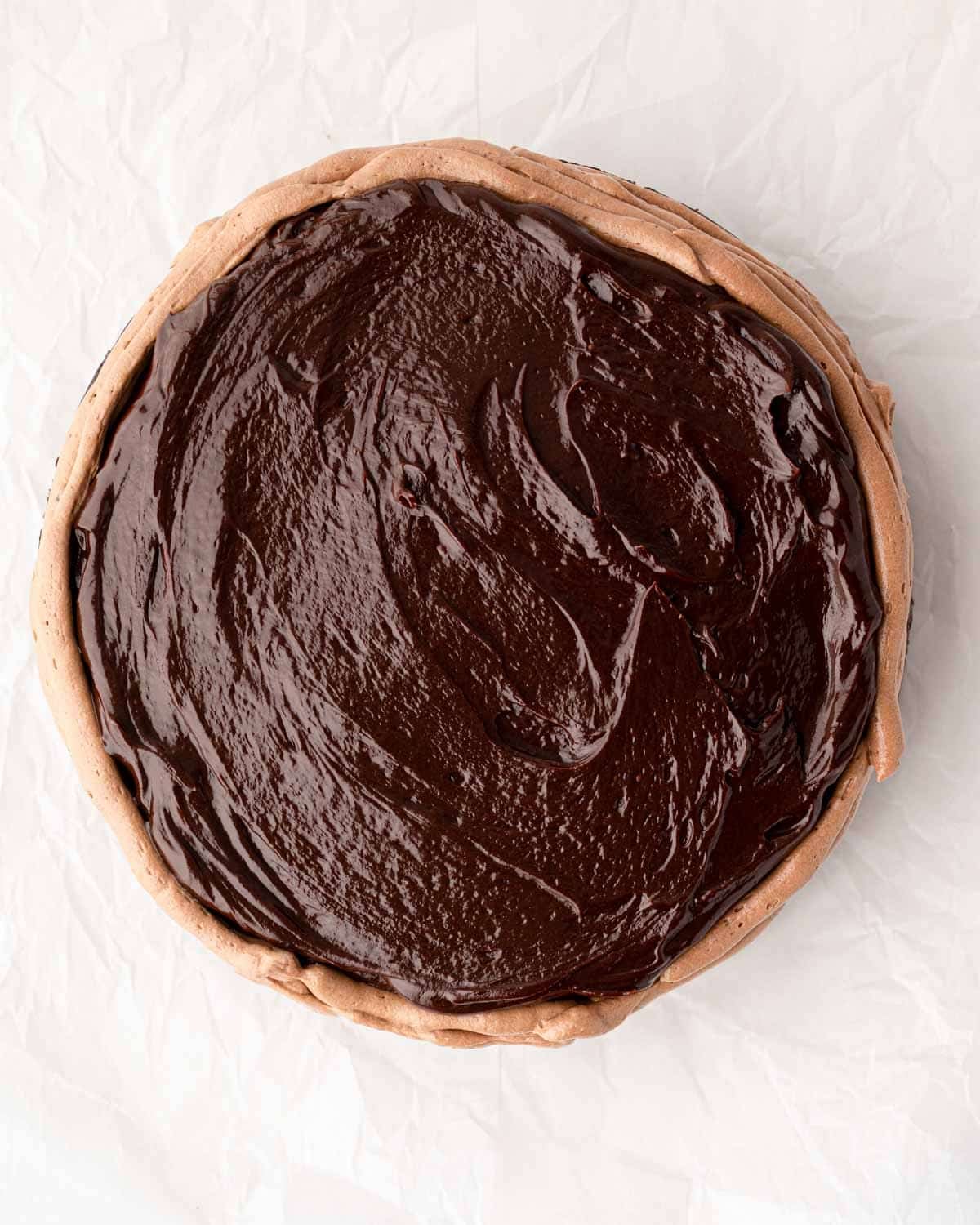 A buttercream dam piped around a round chocolate cake.