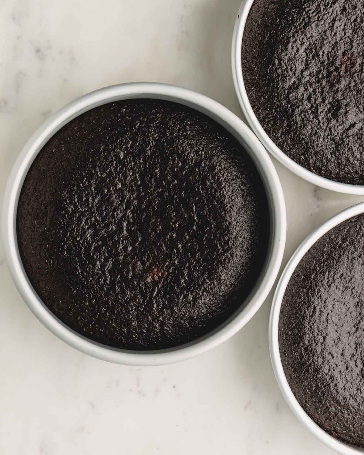 Baked German chocolate cakes in cake pans.