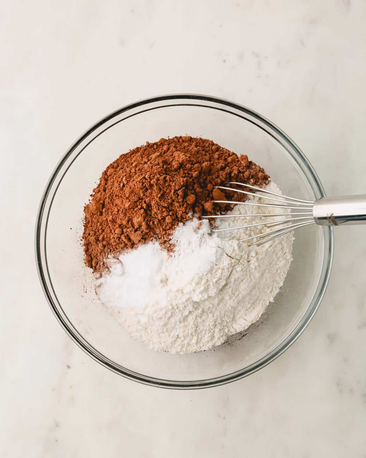 A glass bowl with the dry ingredients for German chocolate cake.