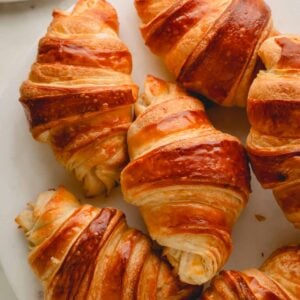 Homemade croissants on a white plate.