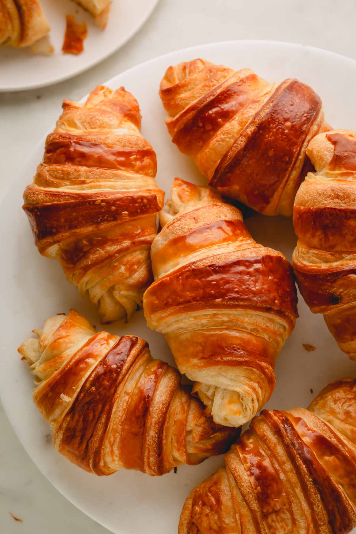 Homemade croissants on a white plate.