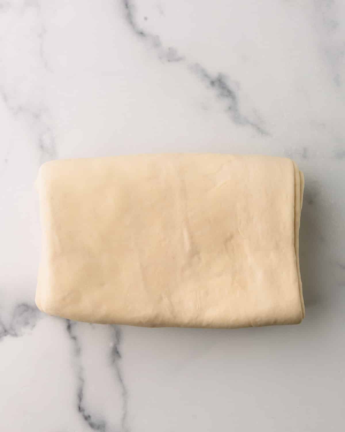 Croissant dough being laminated which means folded several times.