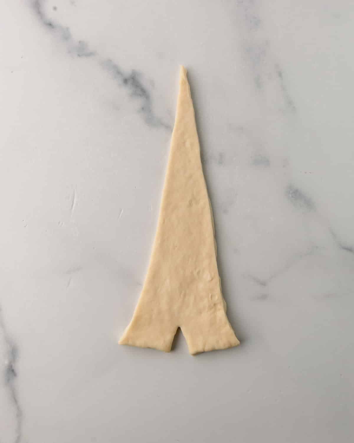 Triangle of croissant dough ready to shape.