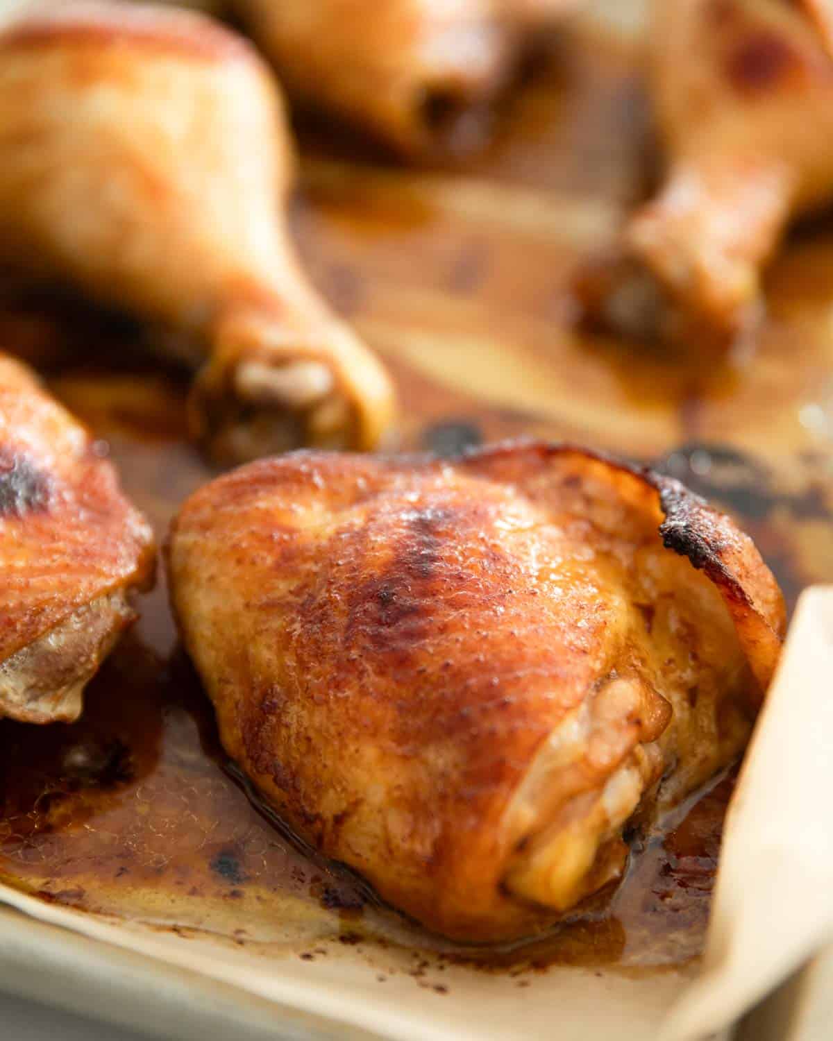 Roasted miso chicken thighs on parchment-lined baking sheet.