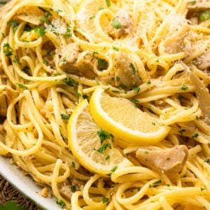 Close up image of lemon artichoke pasta in a white bowl.