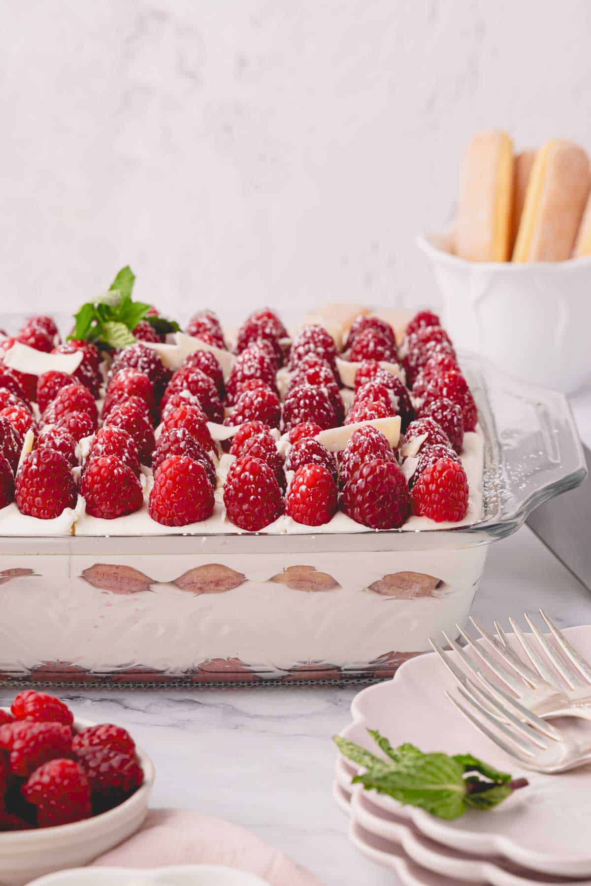 Side image of raspberry tiramisu in a glass baking dish.