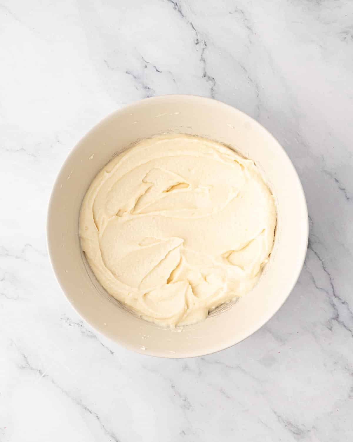 Whipped mascarpone and vanilla in a white bowl.
