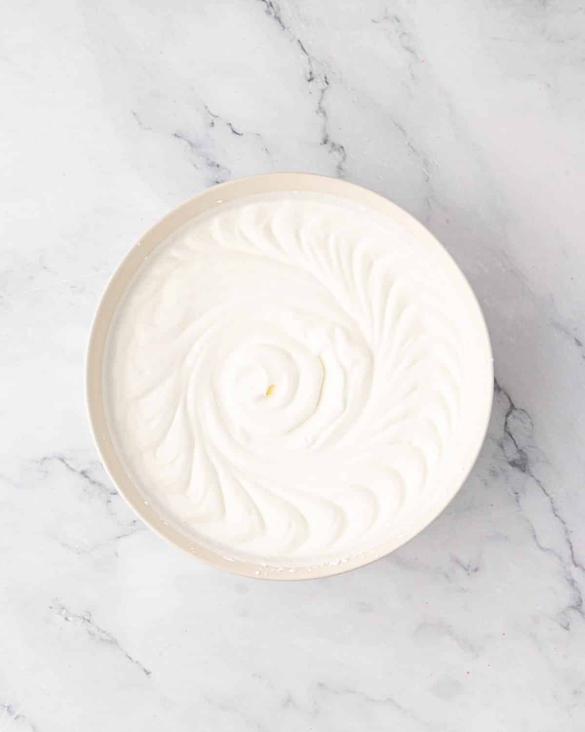 Whipped cream in a white bowl.