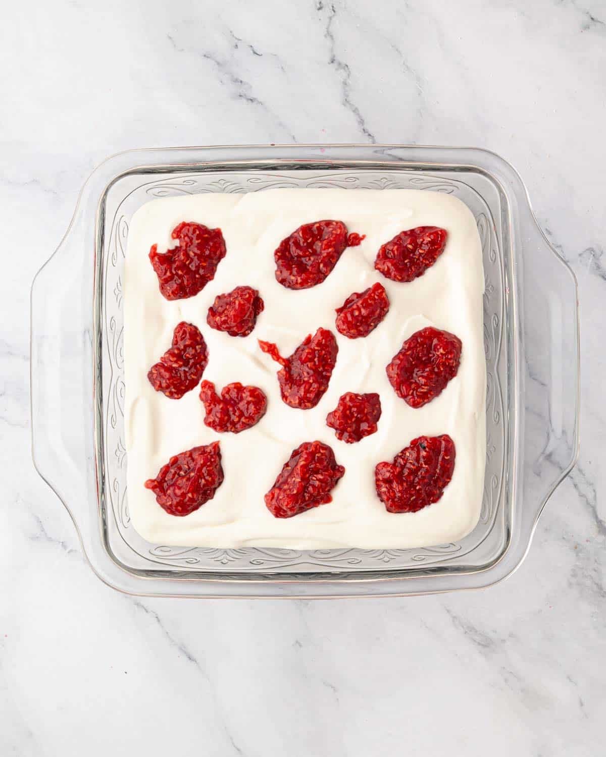 Raspberry compote is added on top of mascarpone cream.