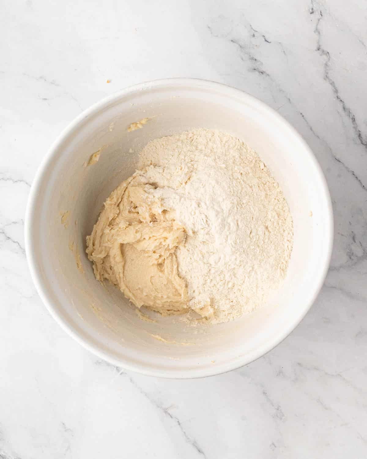 A white bowl with butter and sugar creamed with flour on the side.