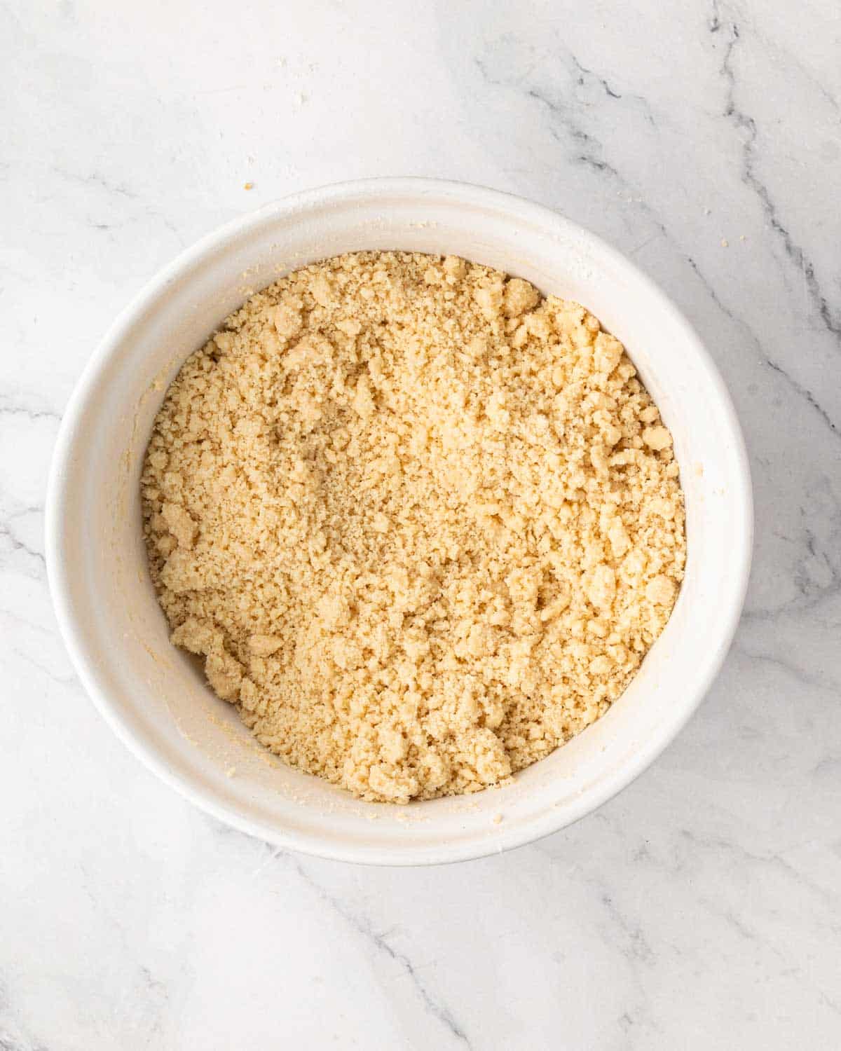A white bowl with shortbread crust mixture.