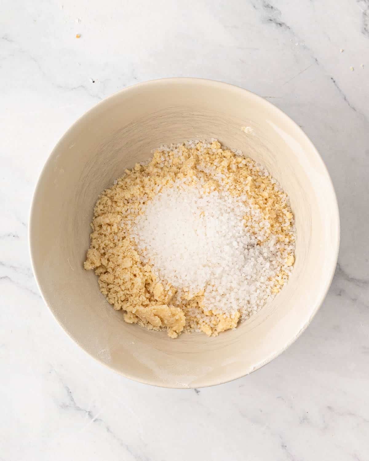 A white bowl with shortbread cookie dough and sugar on top.