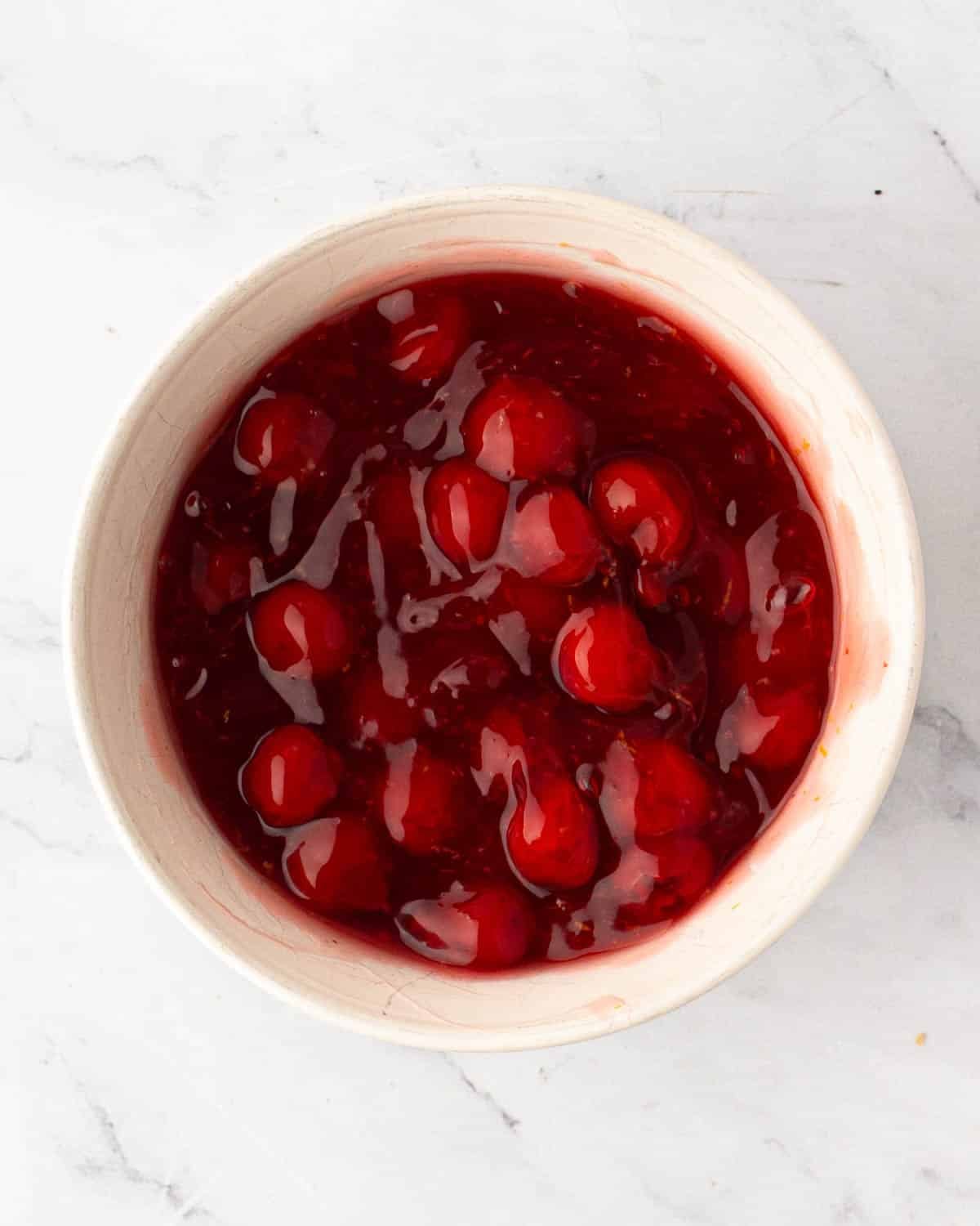 A white bowl with cherry pie filling.