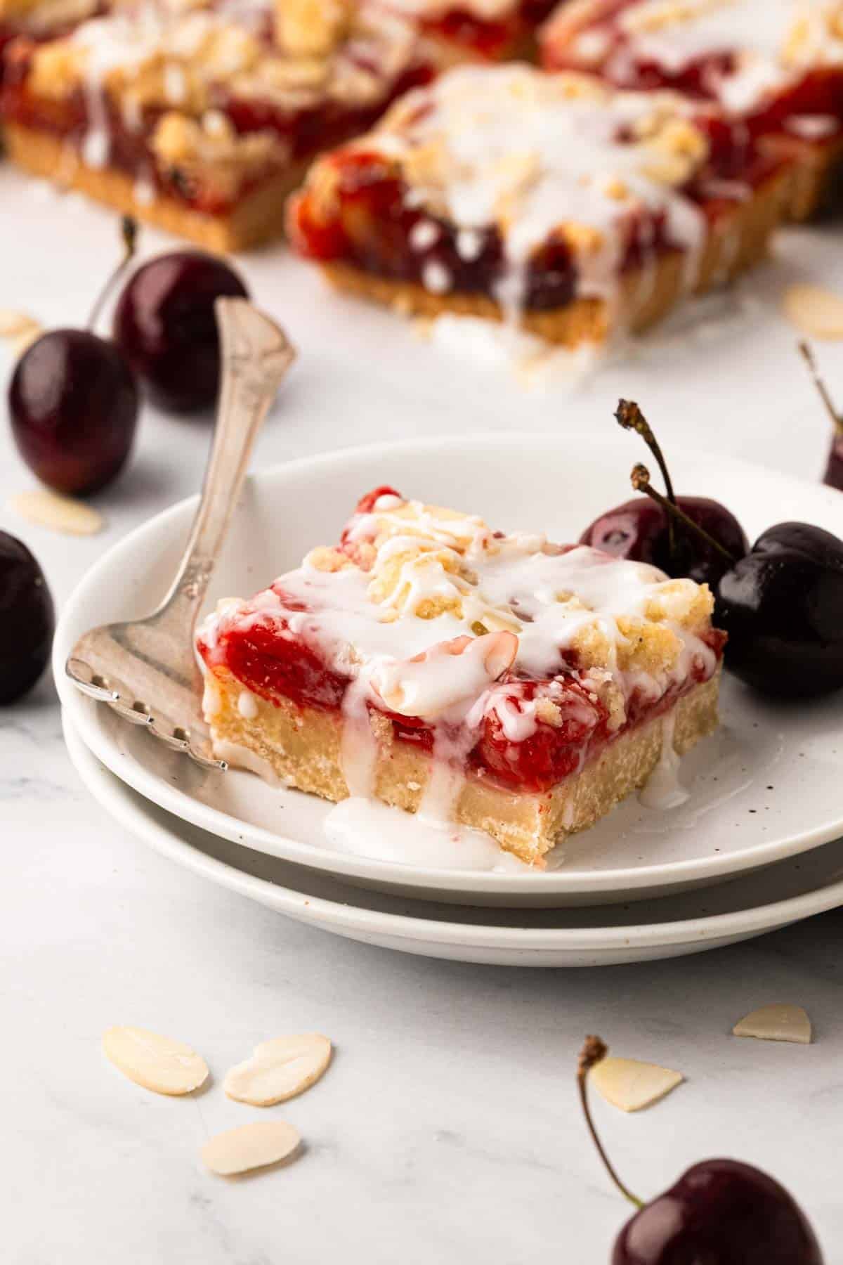 A cherry pie bar on a white plate with a fork.