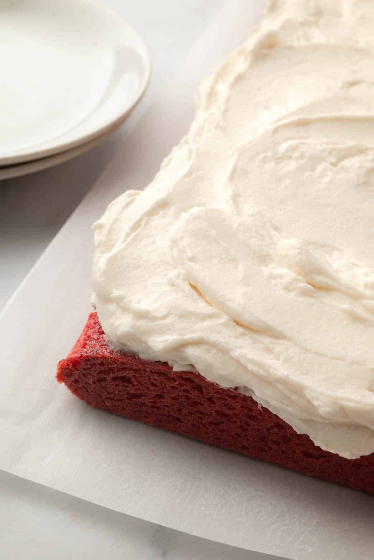Ermine frosting spread onto a red velvet sheet cake.