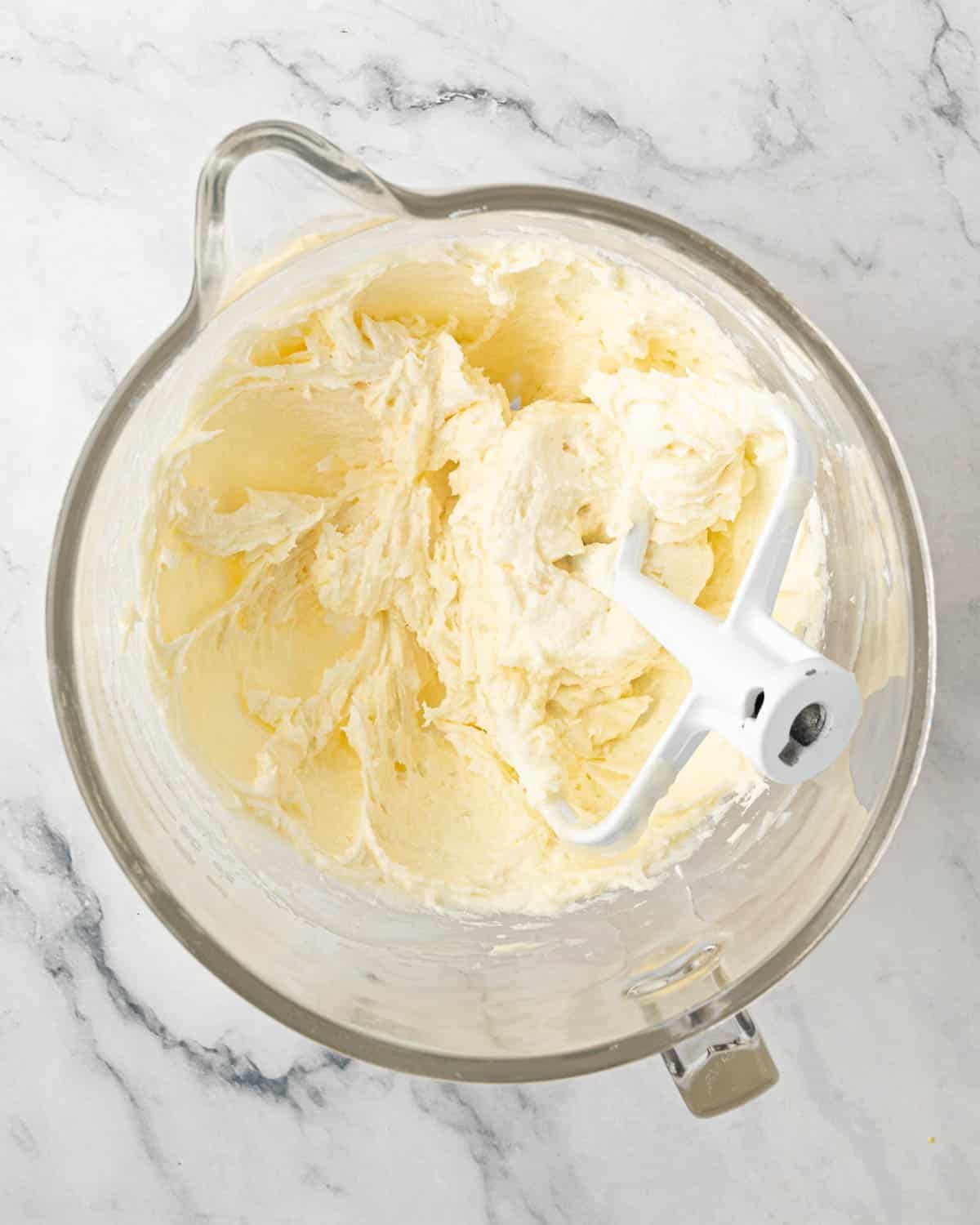 Butter and the roux mixed together for ermine frosting. A paddle attachment is resting to the side.
